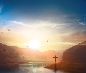 Christ Jesus birth and resurrection concept :Silhouette cross on Calvary mountain sunset background