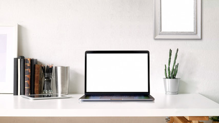 Working space and copy space. mockup poster and blank screen laptop on white desk