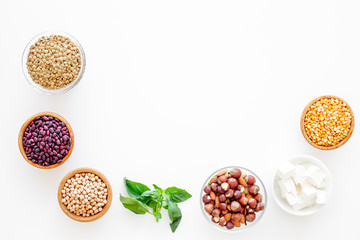 Vegan protein source. Legumes, nuts, cheese, spinach. Raw beans, chickpeas, lentil, almond, hazelnut on white background top view copy space