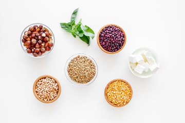 Vegan protein source. Legumes, nuts, cheese, spinach. Raw beans, chickpeas, lentil, almond, hazelnut on white background top view
