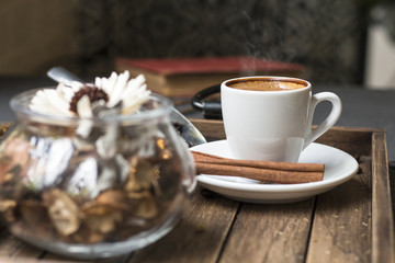 Espresso cup,coffee bean,cinnamon and dried flowers jar on wooden tray with warm morning light near the window.Copy space.