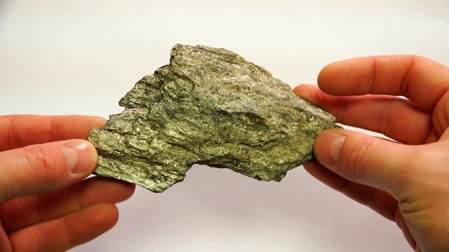 a mineral of dirty green color with a prominent garnet stone.
