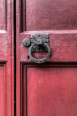 An old weathered and worn red door on a building