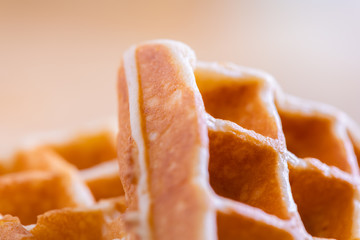 woman hands prepare waffle for serving process.waffle made from dough and batter.tasty dessert sweets waffle served on daylight in cafe bokeh background.waffle with strawberry on black plate.
