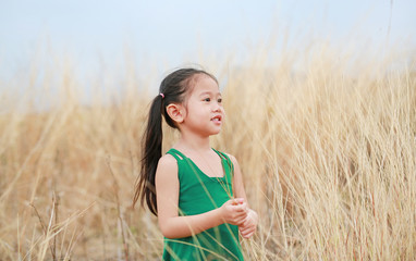 Cute little child girl relaxing in summer field outdoor. Freedom style.