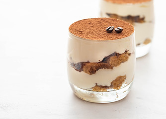 Classic tiramisu in a glass on a white background. Copy space.