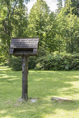 Large wooden bird feeder in the park.