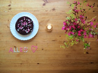 Birthday cake on a table with pink flowers