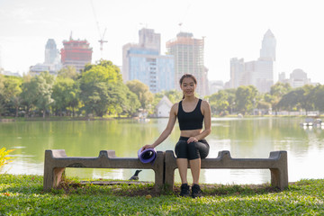 Fototapeta premium Beautiful Asian Woman Sitting In Park Ready For Exercise
