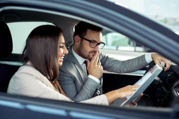 Professional salesperson selling cars at dealership to buyer