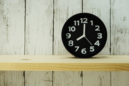 black alarm clock with space for copy on wooden background