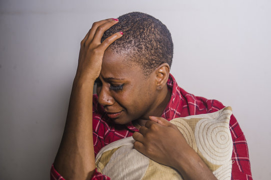 lifestyle indoors portrait of young sad and depressed black african American woman sitting at home floor feeling desperate and worried suffering pain