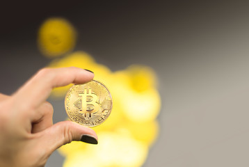 Plakat Hand holding bitcoin on black background. Business concept