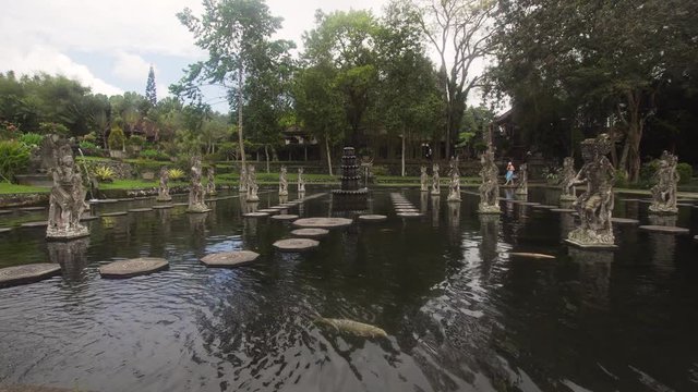 Hindu Balinese Water Palace Tirta Gangga with statues of the gods, fountains on Bali island, Indonesia. Tirta Gangga the former royal water palace is a maze of pools and fountains surrounded by a lush