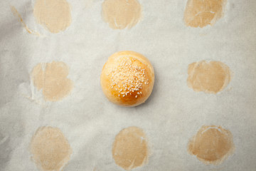 Homemade burger bun on bakery parchment . Food photography, concept of homemade fresh bakery. Rolls with sesame seeds hamburger with sesame, pumpkin, flax, sunflower seeds