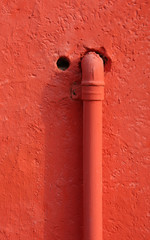 red piping for methane gas that enters the wall