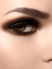 Obraz premium Beautiful macro shot of female eye with extreme long eyelashes and black liner makeup. Perfect shape make-up and long lashes. Cosmetics and make-up. Closeup macro shot of fashion eyes maquillage