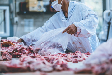 The raw meat packer and the slaughterer work in the slaughterhouse.