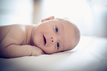 Happy baby boy on bed.