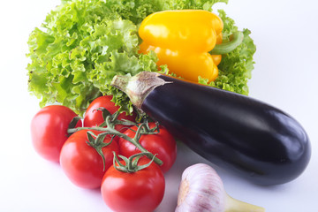Fresh assorted vegetables, eggplant, bell pepper, tomato, garlic with leaf lettuce. Isolated on white background. Selective focus.