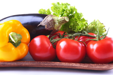 Fresh assorted vegetables, eggplant, bell pepper, tomato, garlic with leaf lettuce. Isolated on white background. Selective focus.