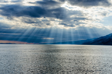 Sun shining through thick cloudy sky, silver lining
