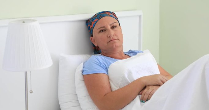 Middle aged  cancer patient laying on bed in hospital room