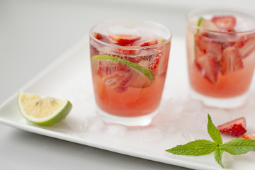 Fresh lemonade with strawberries , lime and mint. On a white background. 