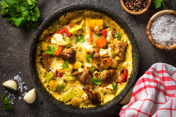 Frittata with meat and vegetables on dark background.