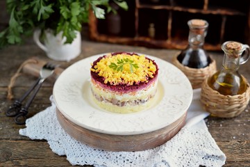 Traditional Russian salad with salted herring, onions, boiled potatoes, eggs, carrots, beets and mayonnaise. Russian salad herring under a fur coat. 