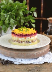 Traditional Russian salad with salted herring, onions, boiled potatoes, eggs, carrots, beets and mayonnaise. Russian salad herring under a fur coat. 