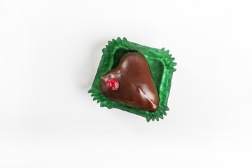 Chocolate heart with currants on white background, from top