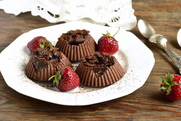 Delicious chocolate souffle with prunes and strawberries sprinkled with cocoa
