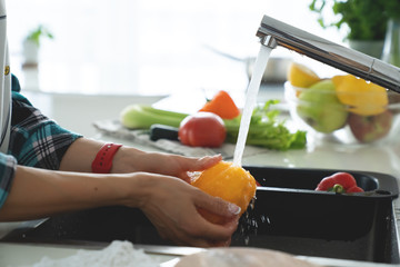 Hands woman washing vegetables. Preparation of fresh salad.