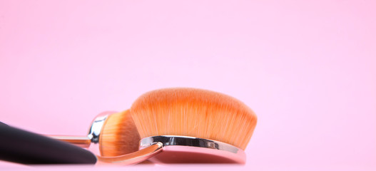 Set of oval brushes for makeup on pink background