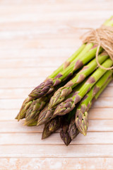 Bunch of fresh asparagus on wooden table.