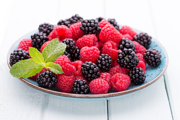Fresh raspberries in a plate on a  vintage background.