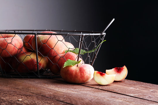 Ripe peaches in basket on wooden background