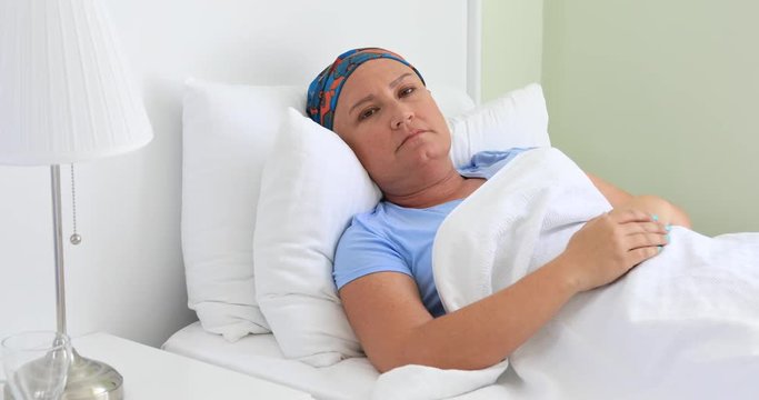 Middle aged  cancer patient laying on bed in hospital room