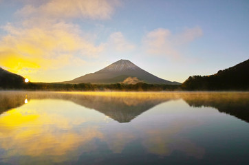 気嵐が立ち上る日の出の精進湖と富士山
