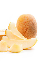 Close up view of whole, half and sliced honeydew melon tropical fruit isolated on a white background.