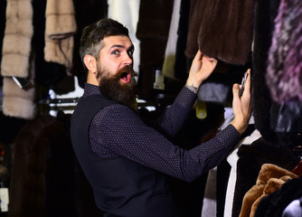 Guy with shocked face looks at fur coat.