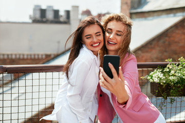 Women Making Photo On Mobile Phone Outdoors