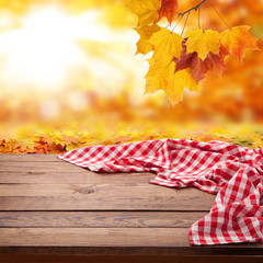 Obraz premium Red checkered tablecloth on wooden table. Napkin close up top view mock up. Autumn rustic background.