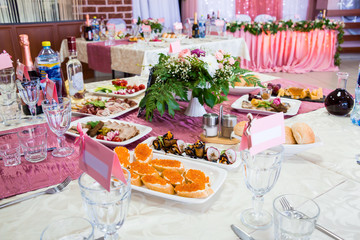 Served tables at the Banquet. Drinks, snacks, delicacies and flowers in the restaurant. A gala event or wedding.