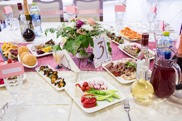 Served tables at the Banquet. Drinks, snacks, delicacies and flowers in the restaurant. A gala event or wedding.