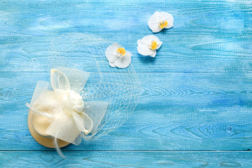 White wedding hat and orchids on a blue wooden background. Wedding background in retro style