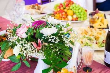 Served table at the Banquet. Fruits, snacks, delicacies and flowers in the restaurant. Solemn event or wedding.
