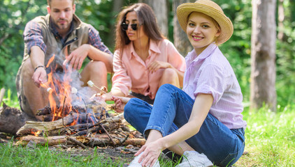 Spend great time on weekend. Roasting marshmallows popular group activity around bonfire. Youth at picnic roasting marshmallows. Company friends prepare roasted marshmallows snack nature background