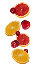 Slices of pink grapefruit, orange and cherry in the fall isolated on white background. Fruit for packing.